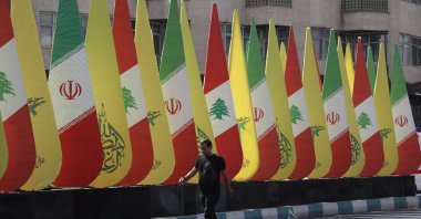 A man walks next to an installation with the flags of Iran, Hezbollah and Lebanon, Tehran, Iran, Oct.18, 2024. (Reuter Photo)