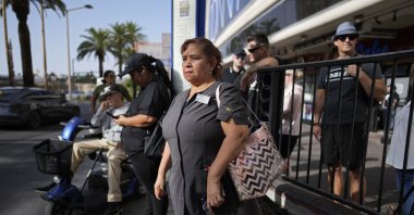 Haydee Zetino, an immigrant from El Salvador who gained temporary protected status since arriving in the wake of a major earthquake in 2001, waits for the bus after working a shift as a maid, Las Vegas, U.S., Sept. 12, 2024. (AP Photo)