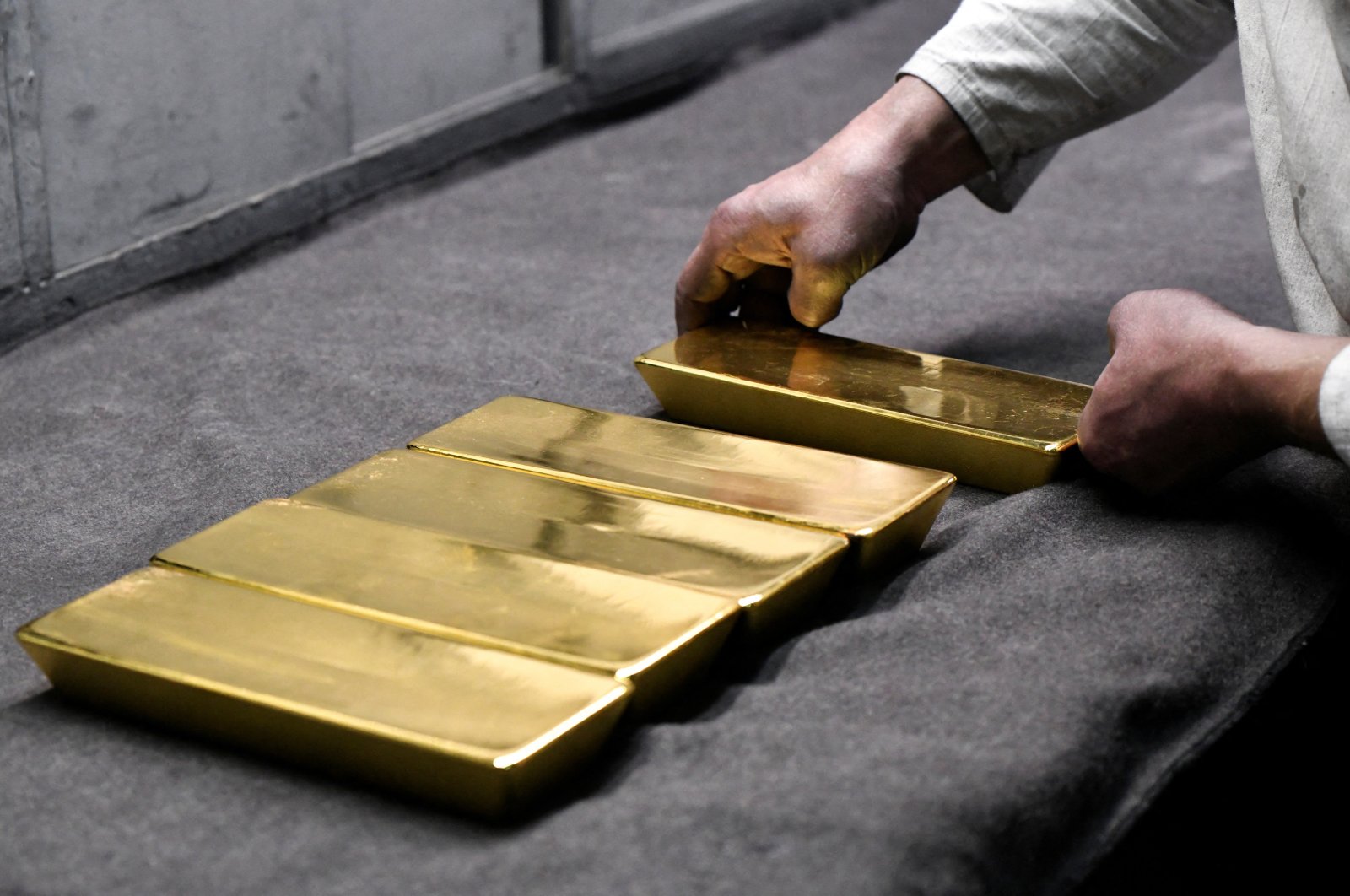 An employee places ingots of 99.99 percent pure gold in a workroom at the Novosibirsk precious metals refining and manufacturing plant in the Siberian city of Novosibirsk, Russia, Sept. 15, 2023. (Reuters Photo)