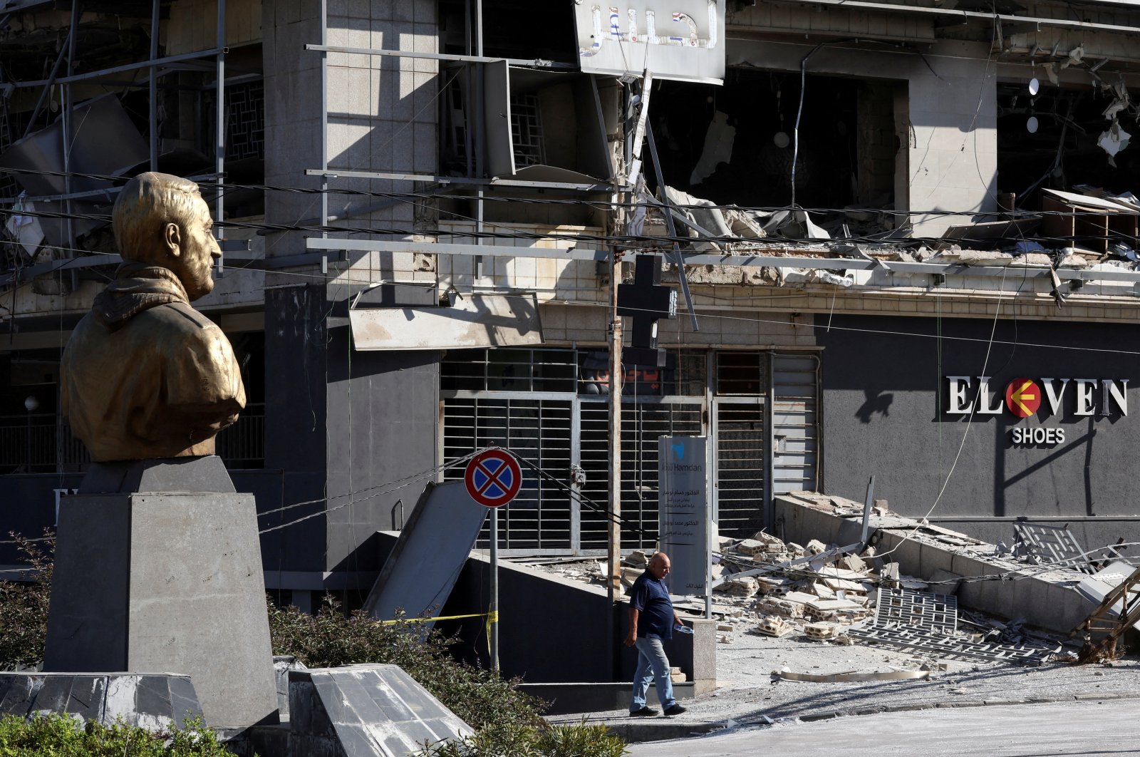 A man walks near a bust depicting late Iranian military commander Gen. Qassem Soleimani, past a site damaged in Israeli airstrikes, Beirut, Lebanon, Oct .21, 2024. (Reuters Photo)