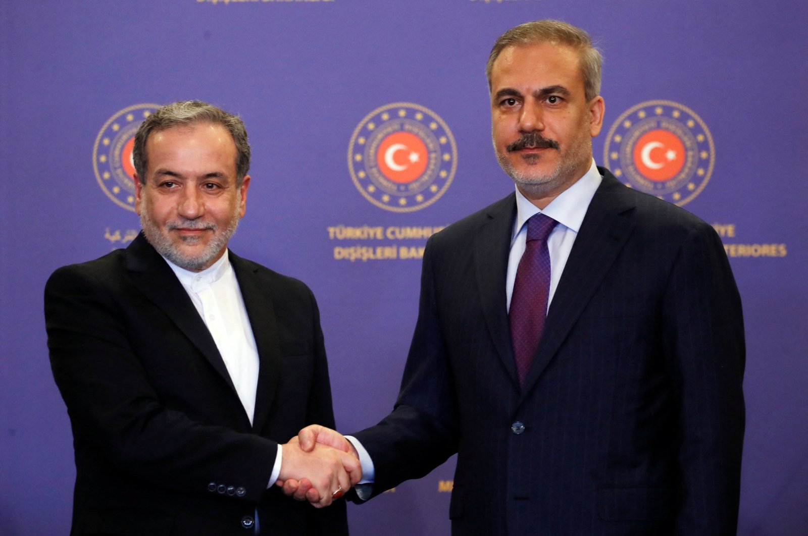 Turkish Foreign Minister Hakan Fidan (R) shakes hands with his Iranian counterpart Abbas Araqchi during a joint news conference, Istanbul, Türkiye, Oct. 19, 2024. (Reuters Photo)