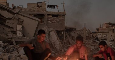 Palestinians sit next to a fire on the rubble of their destroyed home in Khan Younis, southern Gaza Strip, Palestine, Oct. 20, 2024. (EPA Photo)