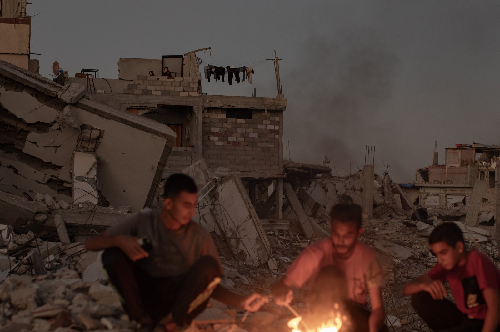 Palestinians sit next to a fire on the rubble of their destroyed home in Khan Younis, southern Gaza Strip, Palestine, Oct. 20, 2024. (EPA Photo)