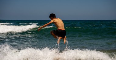 A young man plays with waves at the Kabaköz Beach in the Black Sea town of Şile, Istanbul, Dec. 31, 2022. (Shutterstock Photo)