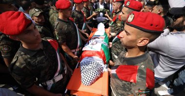 Palestinian security forces carry the body of slain Turkish American activist Aysenur Ezgi Eygi, covered with a chequered keffiyeh and the Palestinian flag, during a memorial service, occupied West Bank, Palestine, Sept. 9, 2024. (AFP Photo)