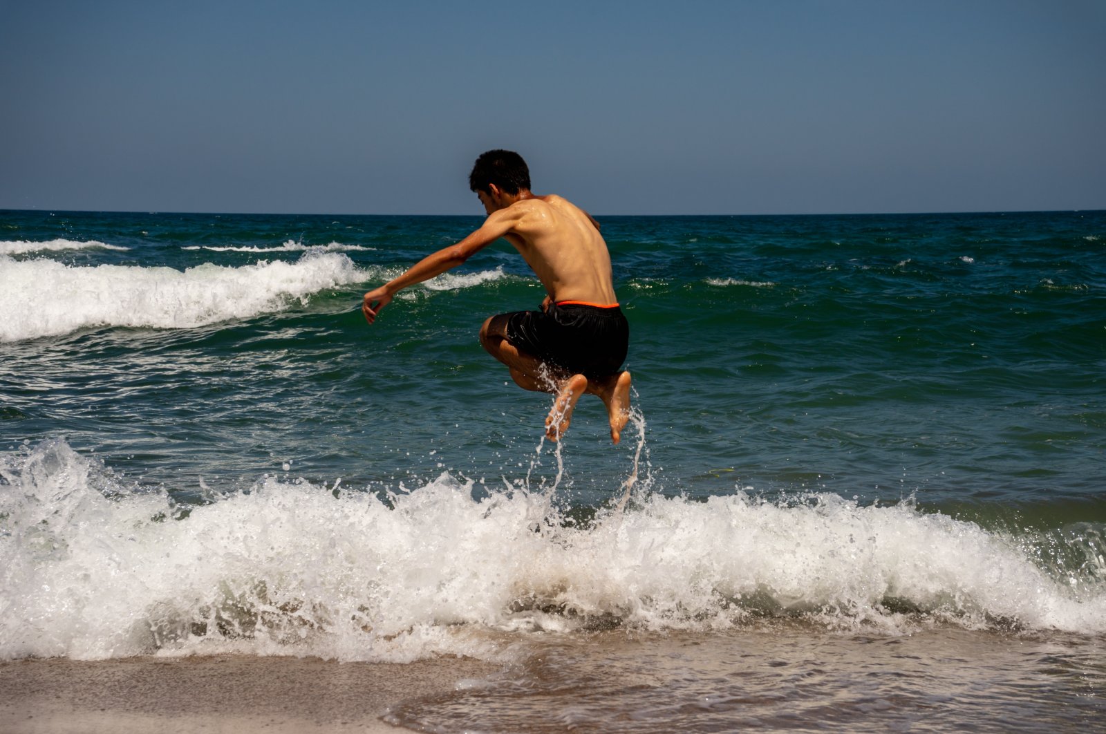 A young man plays with waves at the Kabaköz Beach in the Black Sea town of Şile, Istanbul, Dec. 31, 2022. (Shutterstock Photo)