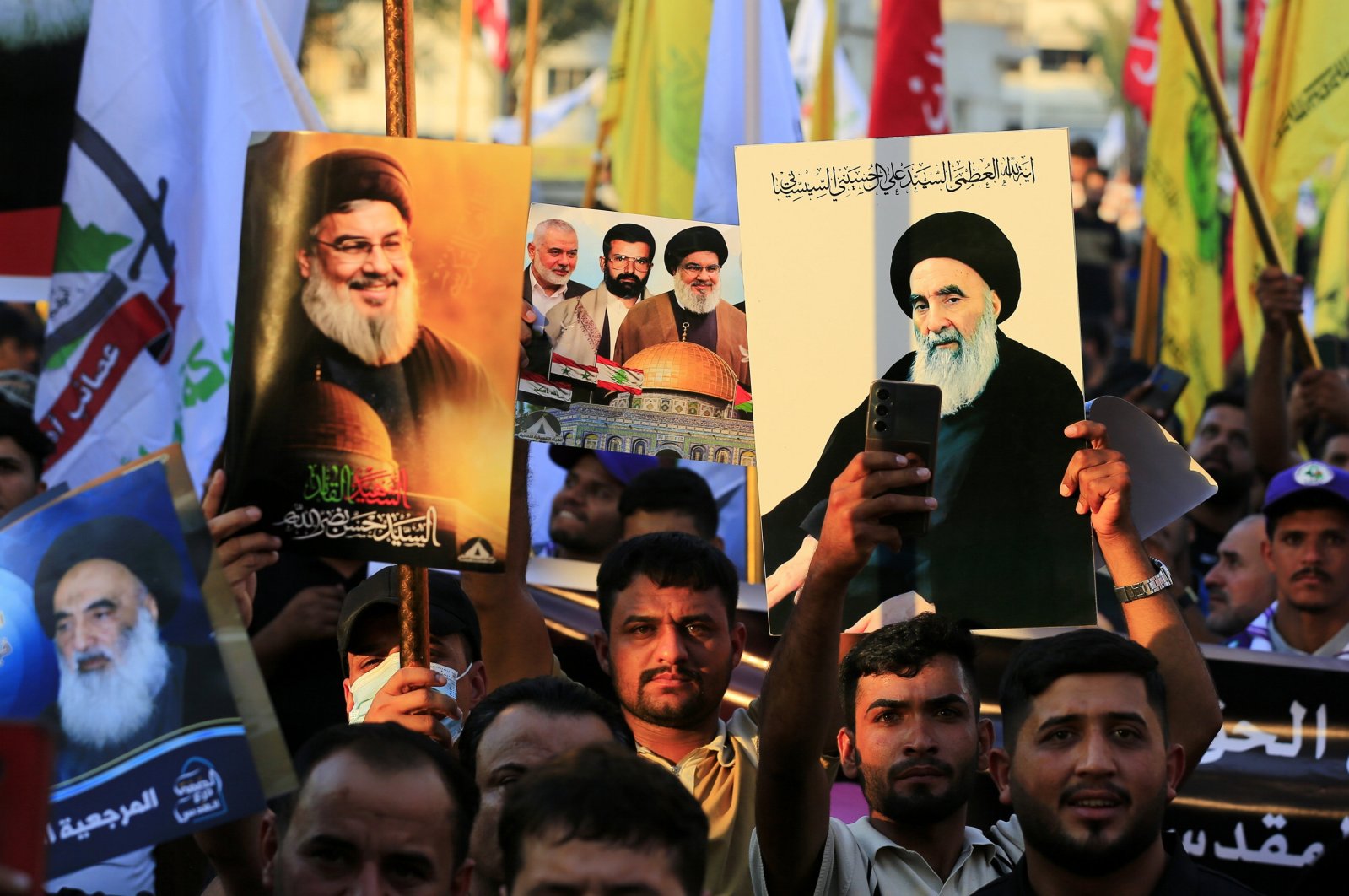 Supporters of the Iran-backed Iraqi Shiite Popular Mobilization Forces carry images of late Hezbollah leader Hassan Nasrallah and Iraq&#039;s top religious authority, Ayatollah Ali al-Sistani, as they take part in a demonstration in solidarity with the Palestinian and Lebanese people, Al-Tahrir Square, Baghdad, Iraq, Oct. 11, 2024. (EPA Photo)