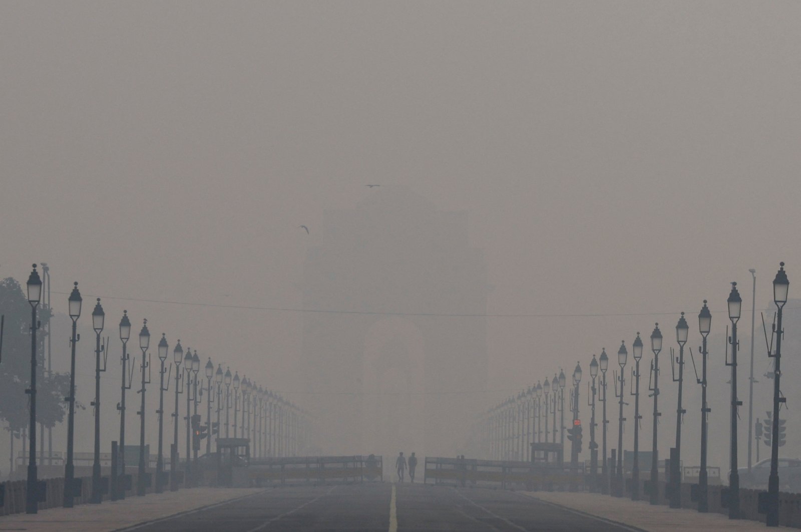 People walk on the Kartavya Path amid the morning smog in New Delhi, India, Oct. 23, 2024. (Reuters Photo)