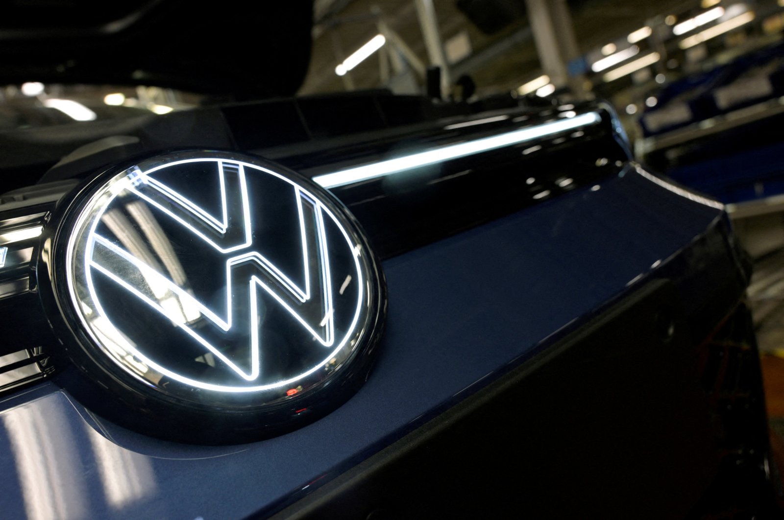 The Volkswagen logo is illuminated on a production line for the Golf VIII and Tiguan cars at the VW headquarters, Wolfsburg, Germany, May 23, 2024. (Reuters Photo)