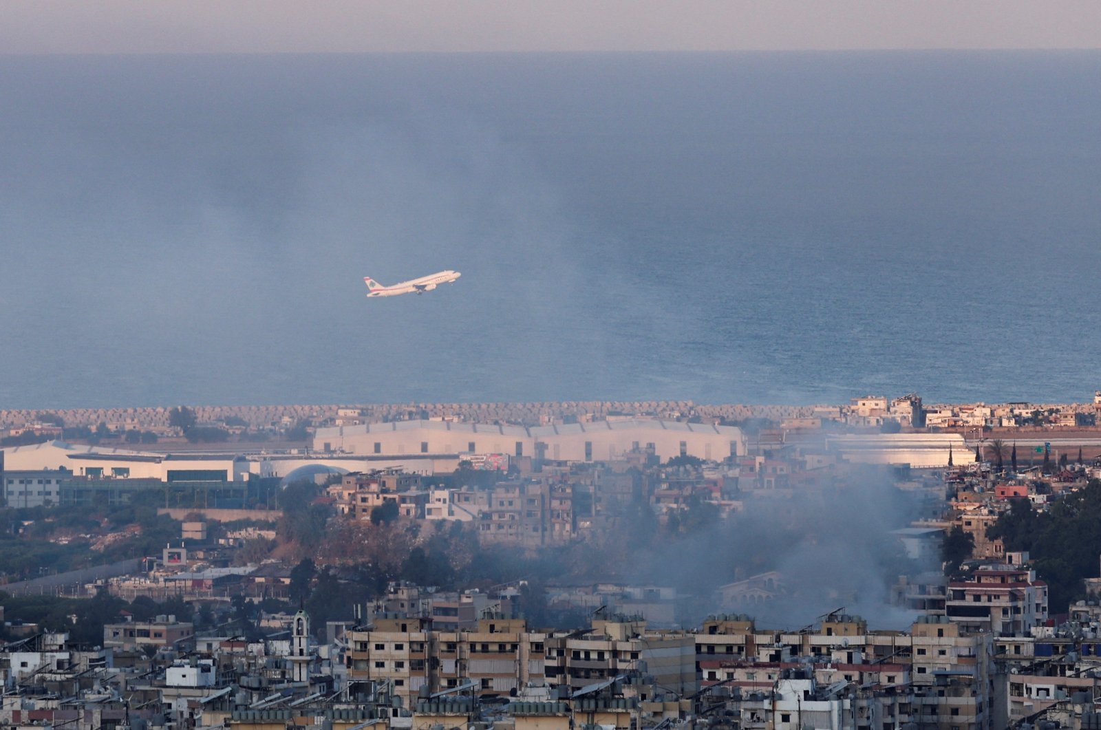 A Lebanese Middle East Airlines (MEA) plane takes off from Beirut-Rafic Hariri International Airport as smoke billows after an Israeli strike in Beirut, Lebanon, Oct. 22, 2024. (Reuters Photo)