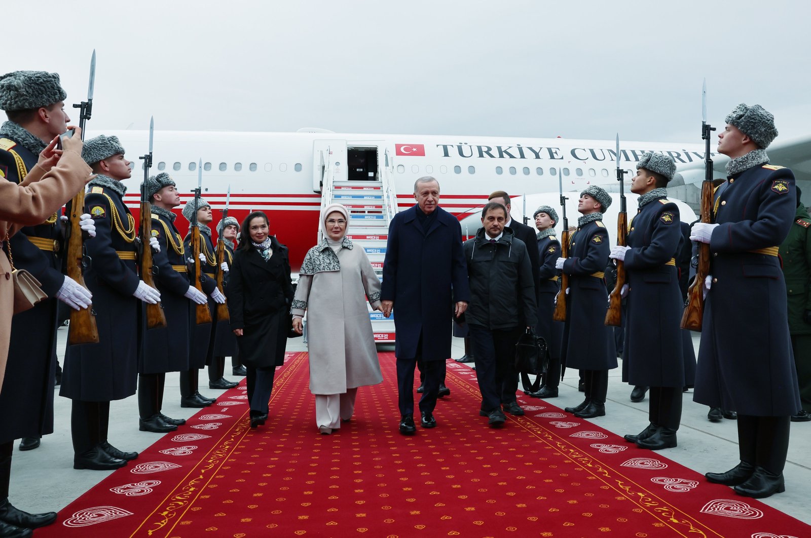 President Recep Tayyip Erdoğan (C) and first lady Emine Erdoğan are welcomed by an official procession as they arrive to attend the BRICS Summit in Kazan, Tatarstan, Russia, Oct. 23, 2024. (AA Photo)