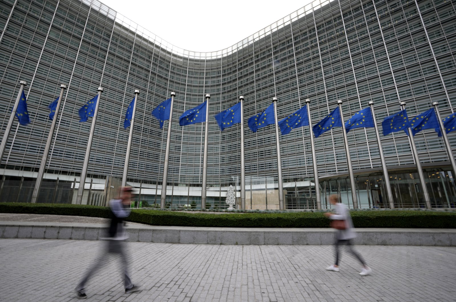 EU flags wave in the wind as pedestrians walk by EU headquarters in Brussels, Belgium, Sept. 20, 2023. (AP Photo)