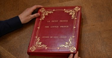 Sammy Jay, Peter Harrington&#039;s literature specialist, holds the casing containing a rare carbon typescript of Antoine de Saint-Exupery&#039;s &quot;Le Petit Prince,&quot; London, U.K., Oct. 15, 2024. (Reuters Photo)