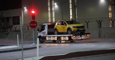 A truck removes a taxi cab that was used by suspects in a terrorist attack at the Turkish Aerospace Industries (TAI) headquarters, Ankara, Türkiye, Oct. 23, 2024. (EPA Photo)