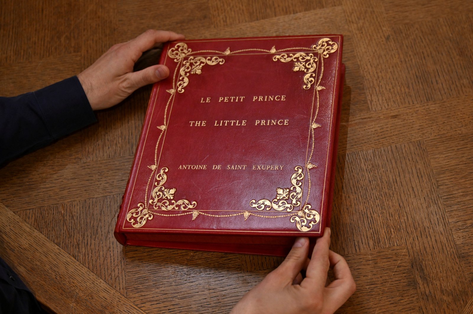 Sammy Jay, Peter Harrington&#039;s literature specialist, holds the casing containing a rare carbon typescript of Antoine de Saint-Exupery&#039;s &quot;Le Petit Prince,&quot; London, U.K., Oct. 15, 2024. (Reuters Photo)