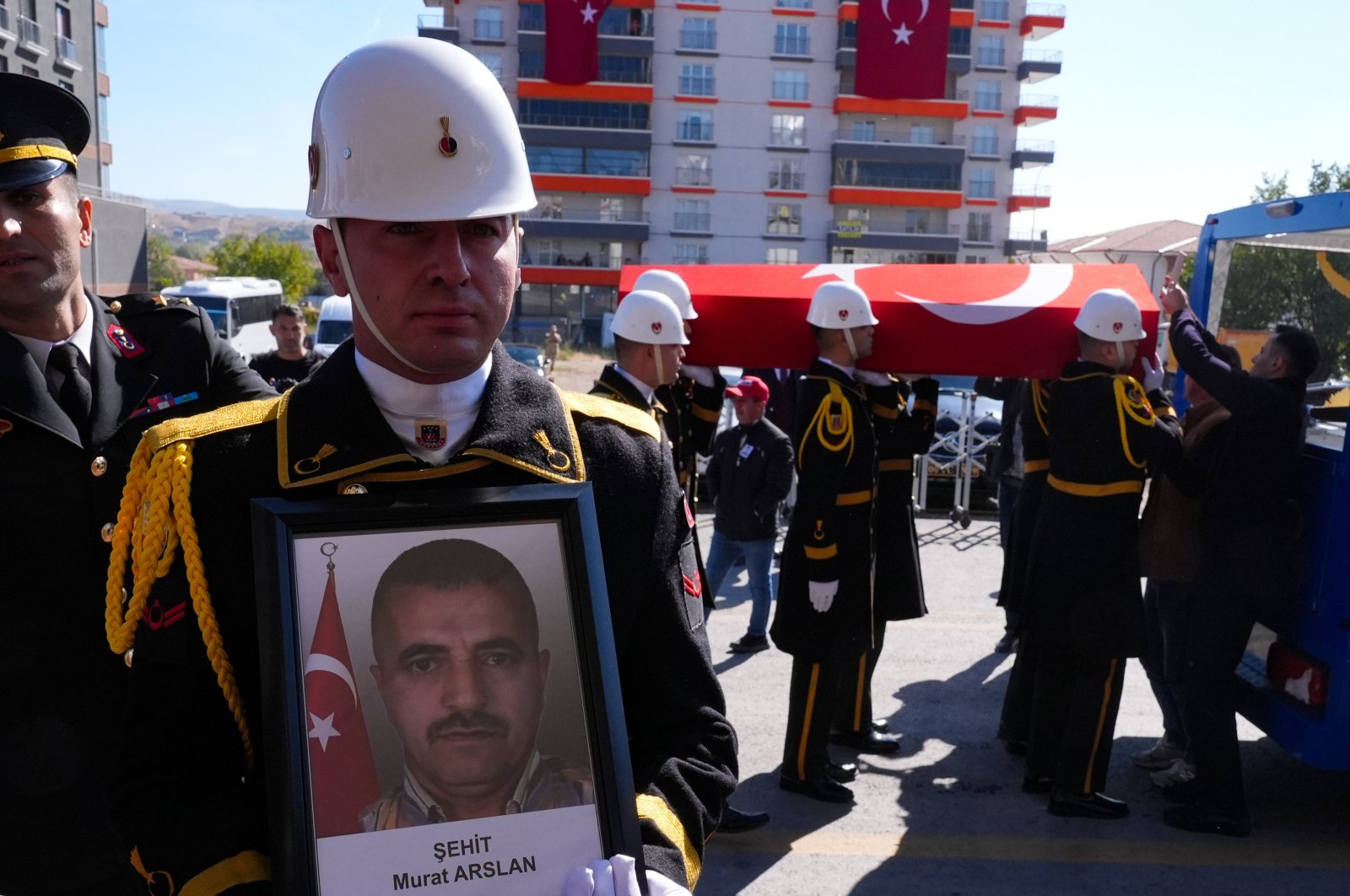 A Turkish soldier holds a portrait of Murat Arslan, one of the victims killed in a PKK attack on aviation company TUSAŞ, as he is laid to rest in the capital Ankara, Türkiye, Oct. 24, 2024. (AA Photo)