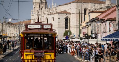 Tourists take pictures as the historical trams of Carris (Lisbon’s public transport) take part in the annual parade of classical trams and buses in celebration of the 152nd anniversary of the company, Lisbon, Portugal, Sept. 21, 2024. (AFP Photo)