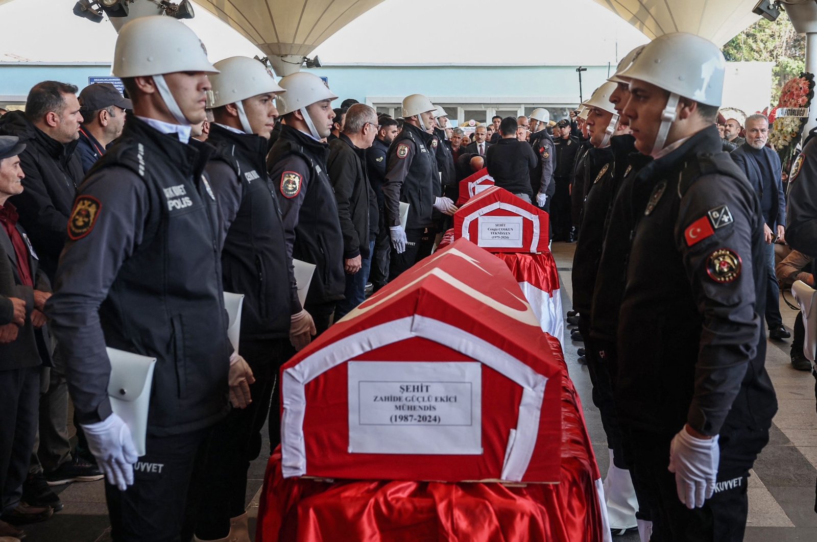 A Turkish police honor guard stands next to the coffins of Zahide Güçlü Ekici, Hasan Huseyin Canbaz and Cengiz Coşkun during their funeral, the day after they were killed in a terrorist attack on the state-run Turkish Aerospace Industries (TAI) building, Ankara, Türkiye, Oct. 24, 2024. (AFP Photo)