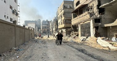 Palestinians walk past damaged and destroyed buildings in Beit Lahia, northern Gaza Strip, Palestine, Oct. 26, 2024. (AFP Photo)