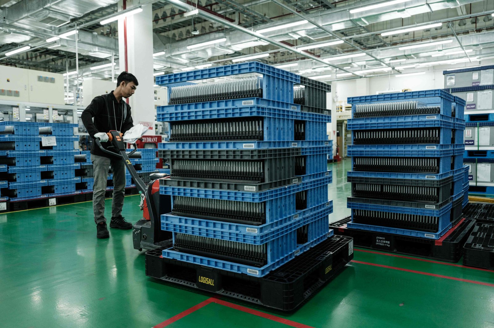 A worker moves battery cells to be packed for shipment at the battery manufacturing plant at PT HLI Green Power, Indonesia&#039;s first EV battery cell manufacturer, Karawang, West Java, Indonesia, Aug. 28, 2024. (AFP Photo)