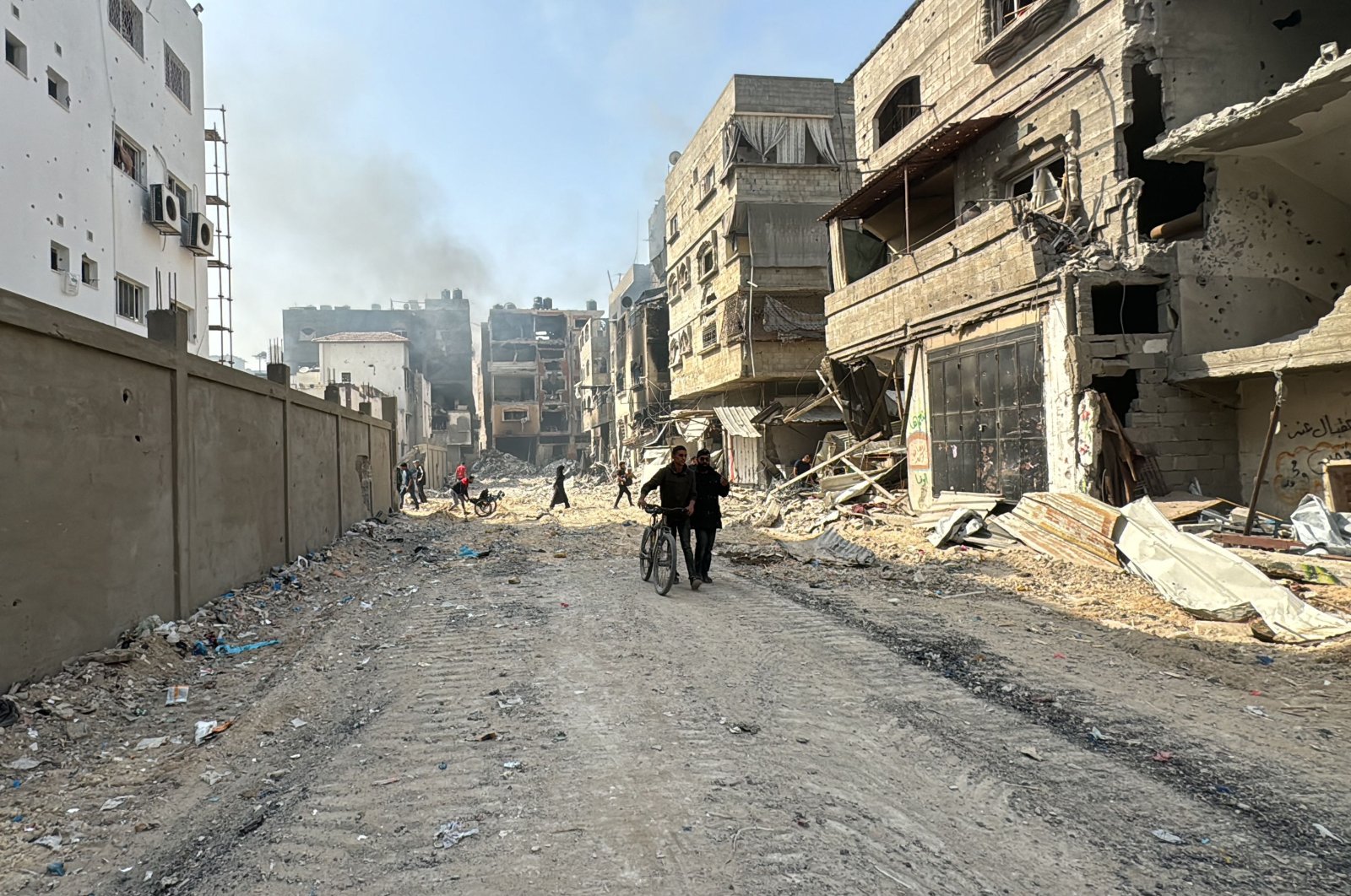 Palestinians walk past damaged and destroyed buildings in Beit Lahia, northern Gaza Strip, Palestine, Oct. 26, 2024. (AFP Photo)