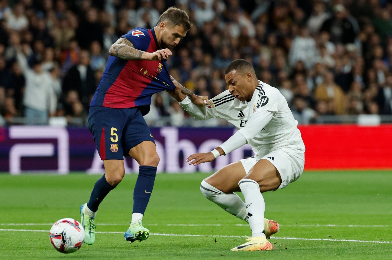 Barcelona&#039;s Inigo Martinez Berridi (L) and Real Madrid&#039;s Kylian Mbappe vie for the ball during a La Liga match in Madrid, Spain, Oct. 26, 2024. (AFP Photo)