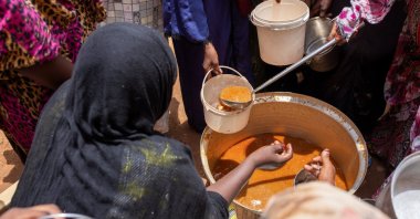 Sudanese women from community kitchens distribute meals for people affected by conflict and extreme hunger, Omdurman, Sudan, July 27, 2024. (Reuters Photo)