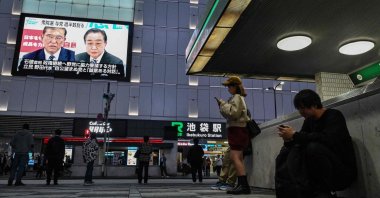 People stand outside Ikebukuro train station as images of Japan&#039;s Prime Minister Shigeru Ishiba (top L) and former premier and head of the opposition Constitutional Democratic Party (CDP), Yoshihiko Noda (top R) are broadcast during a news update on a large television screen after the general election in Tokyo, Japan, Oct. 28, 2024. (AFP Photo)