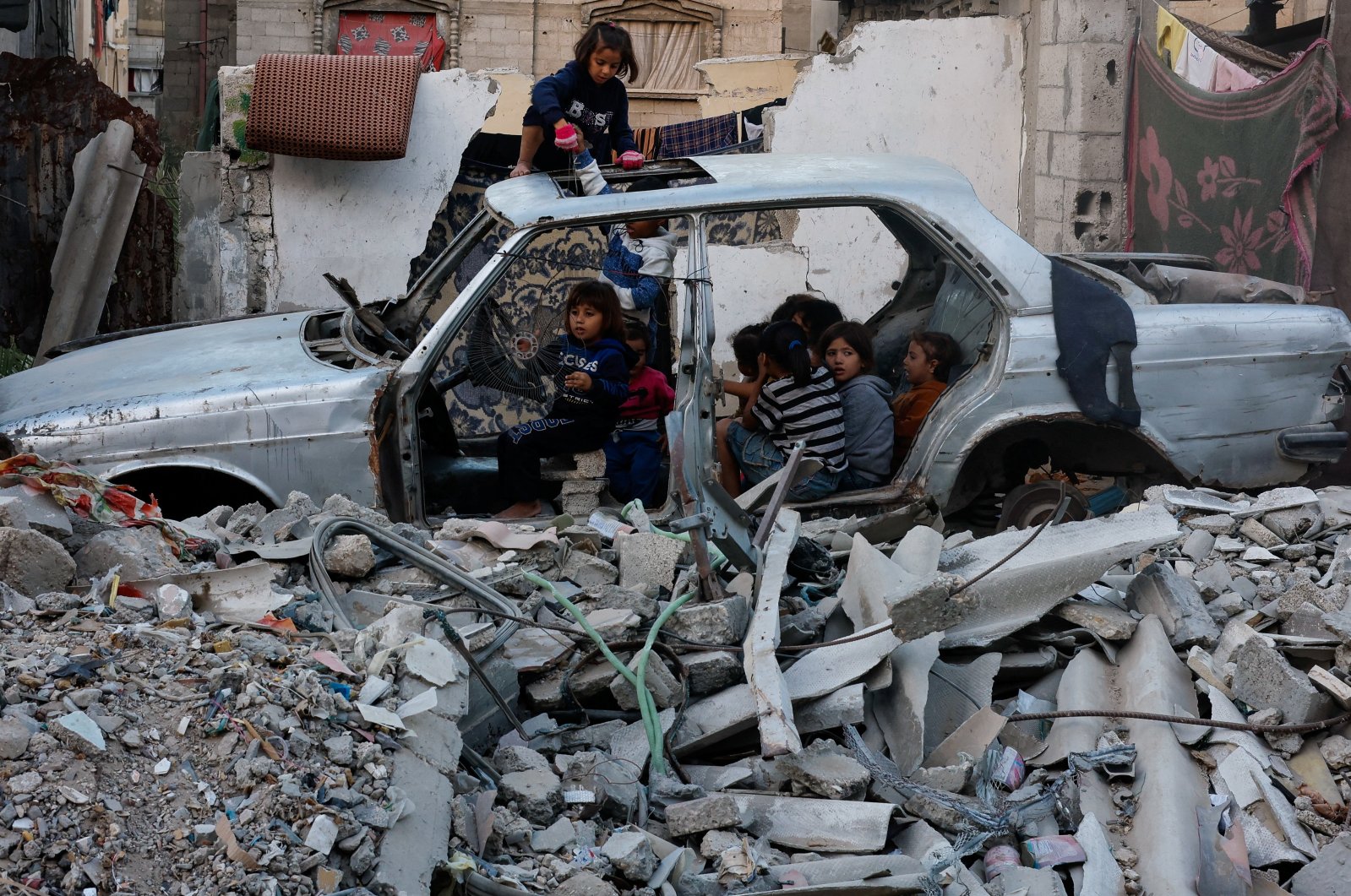 ISRAEL-PALESTINIANS/GAZA
Palestinian children gather at a destroyed vehicle, amid the Israel-Hamas conflict, in Khan Younis, in the southern Gaza Strip, October 27, 2024. REUTERS/Mohammed Salem