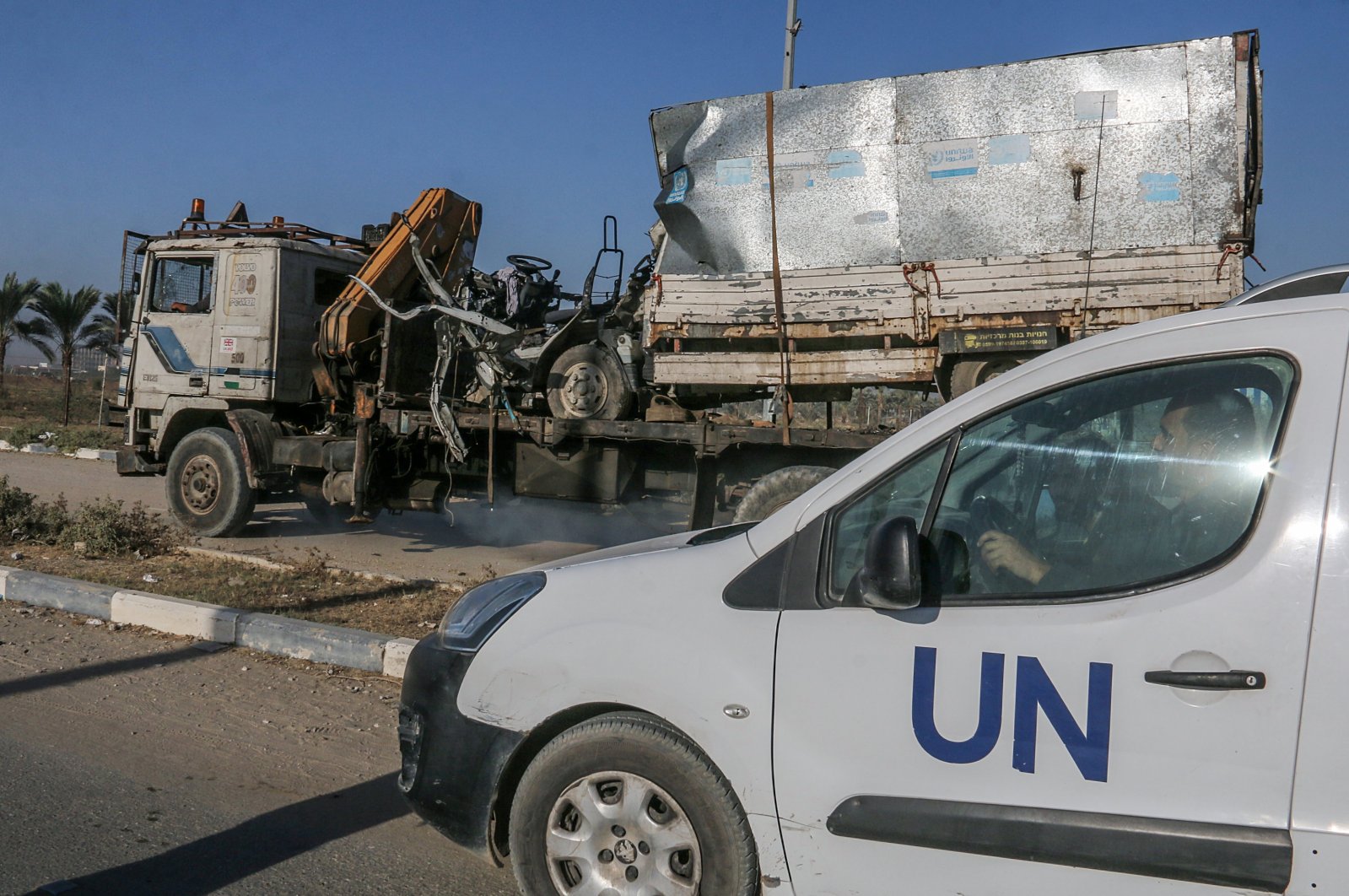 A destroyed truck that was used by workers of the United Nations Relief and Works Agency for Palestine Refugees (UNRWA) is loaded onto another truck after it was hit in an Israeli air strike on Salah Al Dine road between Deir Al Balah and Khan Younis town, southern Gaza Strip, Palestine, Oct. 23, 2024. (EPA Photo)