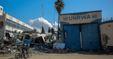 People walk past the damaged Gaza City headquarters of the United Nations Relief and Works Agency for Palestine Refugees (UNRWA), Gaza, Palestine, Feb. 15, 2024. (AFP Photo)