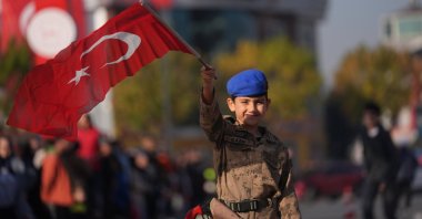 A boy dressed as a soldier waves the Turkish flag during a Republic Day parade, Düzce, Türkiye, Oct. 29, 2024. (AA Photo)