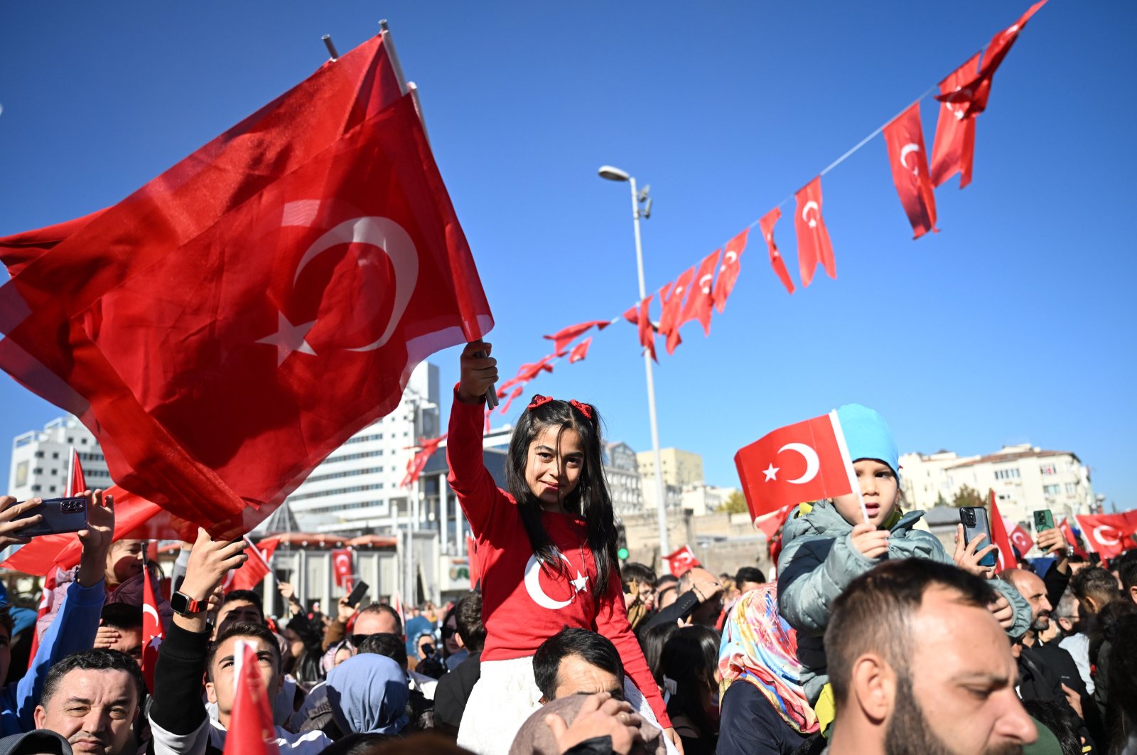 A girl celebrates while holding Türkiye&#039;s flag during the walk on Cumhuriyet Street, Kayseri, Türkiye, Oct. 29, 2024. (AA Photo)