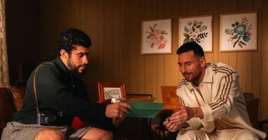 A still photo shows Inter Miami&#039;s Argentinian forward Lionel Messi (R) and rapper Bad Bunny reading fan mail in an Adidas ad video. (Adidas on Instagram)