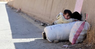A child holds onto their belongings while crossing from Lebanon into Syria at Masnaa border crossing, Lebanon, Oct. 28, 2024. (Reuters Photo)