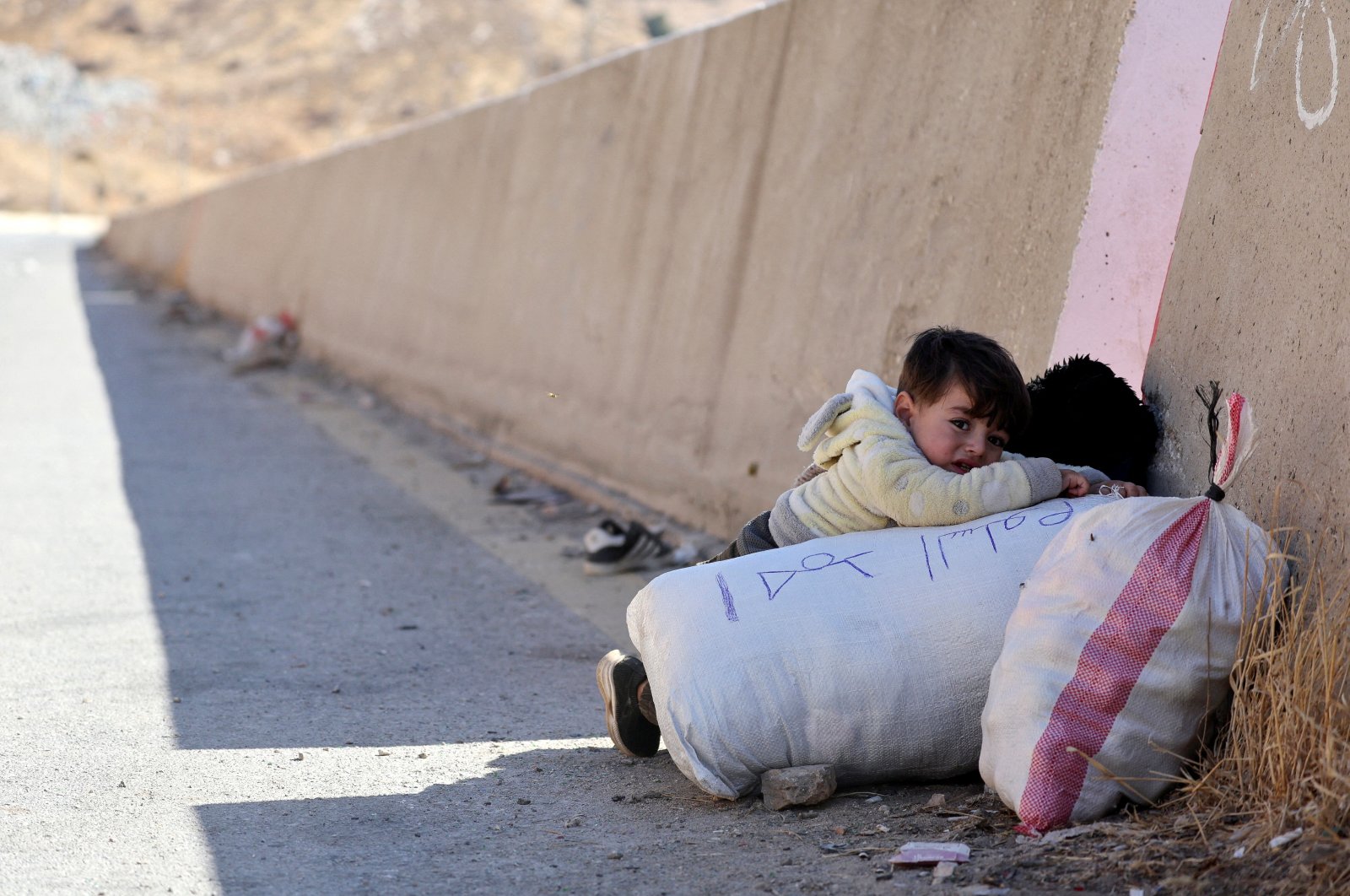 A child holds onto their belongings while crossing from Lebanon into Syria at Masnaa border crossing, Lebanon, Oct. 28, 2024. (Reuters Photo)