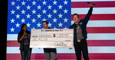 SpaceX and Tesla founder Elon Musk awards Judey Kamora $1 million during an America PAC town hall, in Lancaster, Pennsylvania, Oct. 26, 2024. (AFP Photo)