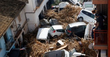 People look from a balcony at a street with piled up cars in the aftermath of torrential rains that caused flooding, in Paiporta, Spain, Oct. 31, 2024. (Reuters Photo)