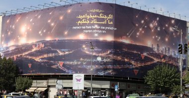 Commuters drive past an anti-Israel billboard covering the facade of a building in Tehran, Iran, Oct. 26, 2024. (AFP Photo)
