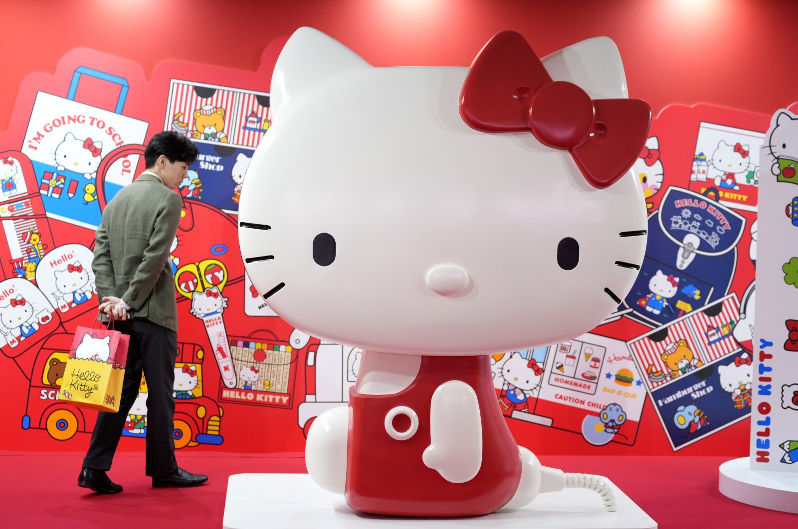 A visitor looks at the giant Hello Kitty display at the exhibition &quot;As I Change, So Does She,&quot; marking the 50th anniversary of Hello Kitty at the Tokyo National Museum, Tokyo, Japan, Oct. 30, 2024. (AP Photo)