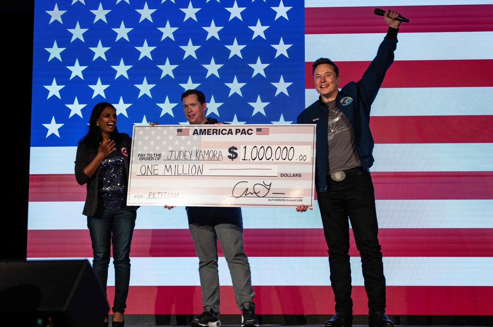 SpaceX and Tesla founder Elon Musk awards Judey Kamora $1 million during an America PAC town hall, in Lancaster, Pennsylvania, Oct. 26, 2024. (AFP Photo)