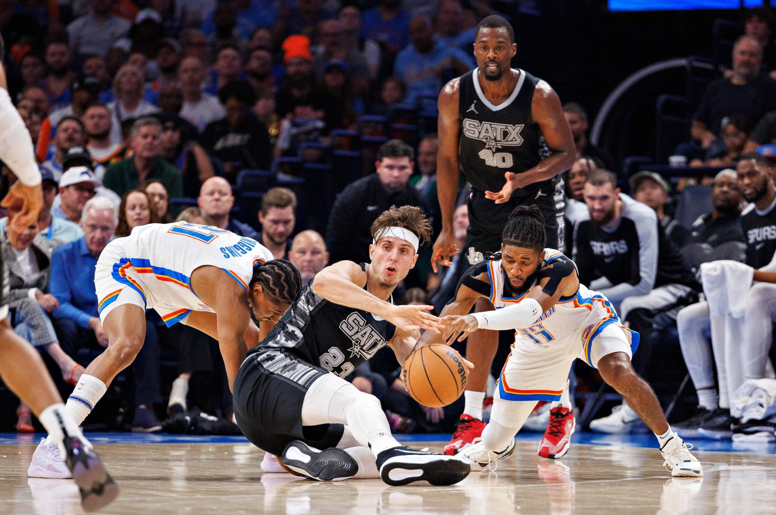 San Antonio Spurs&#039; Zach Collins (C) fights for a loose ball in the second half against Oklahoma City Thunder&#039;s Isaiah Joe (R) at Paycom Center, Oklahoma City, Oklahoma, U.S., Oct. 30, 2024. (AFP Photo)