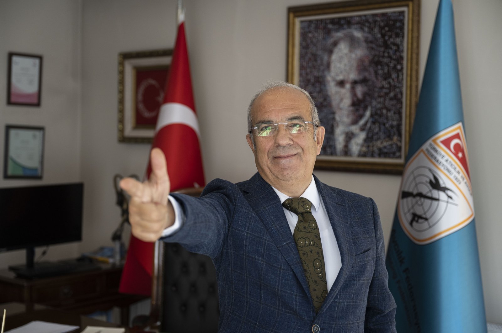 Turkish Shooting Federation President Murat Kocakaya shows off the "Yusuf Dikeç pose", Istanbul, Türkiye, Oct. 30, 2024. (AA Photo)