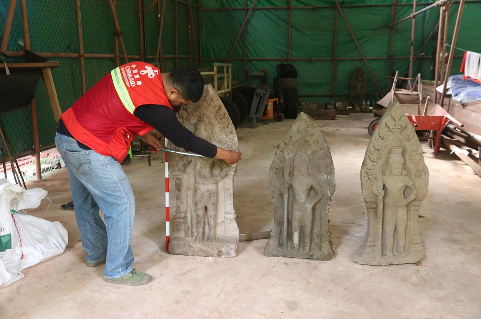 This handout photo provided by Apsaras National Authority shows a centuries-old sandstone statue being measured at Angkor Thom, Cambodia, Oct. 24, 2024. (AP Photo)