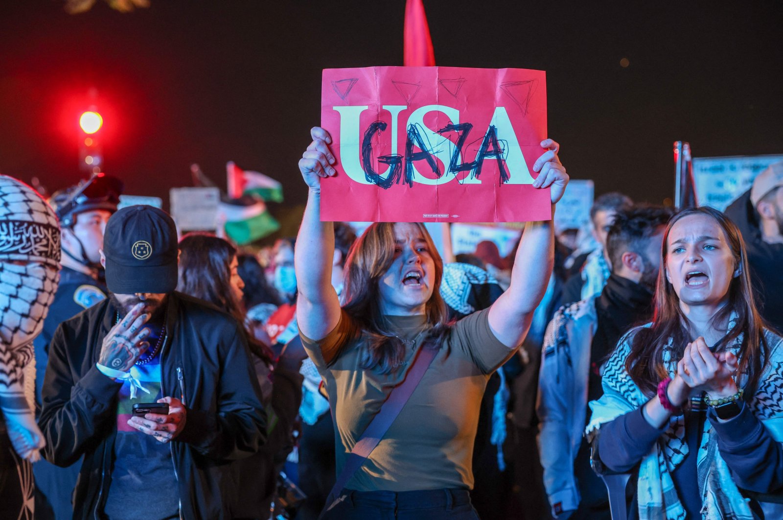 A protester holds up a sign reading &quot;USA&quot; with &quot;Gaza&quot; written on top south of the White House, Washington, DC, Oct. 29, 2024. (AFP Photo)