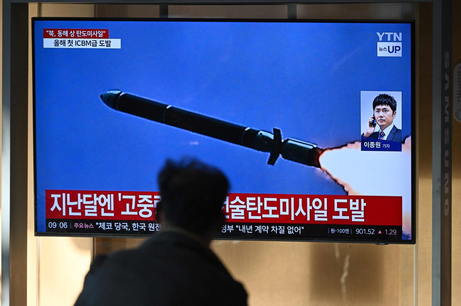 A man watches a television screen showing a news broadcast with file footage of a North Korean missile test, at a train station in Seoul on October 31, 2024. North Korea on October 31 fired a "long-range ballistic missile", South Korea's military said, Pyongyang's first weapons test since Seoul accused it of sending tens of thousands of soldiers to Russia. (Photo by JUNG YEON-JE / AFP)