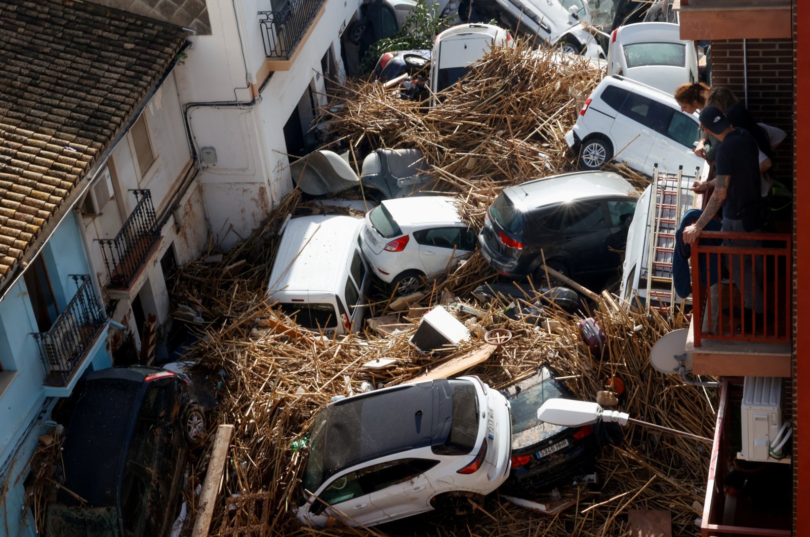 People look from a balcony at a street with piled up cars in the aftermath of torrential rains that caused flooding, in Paiporta, Spain, Oct. 31, 2024. (Reuters Photo)