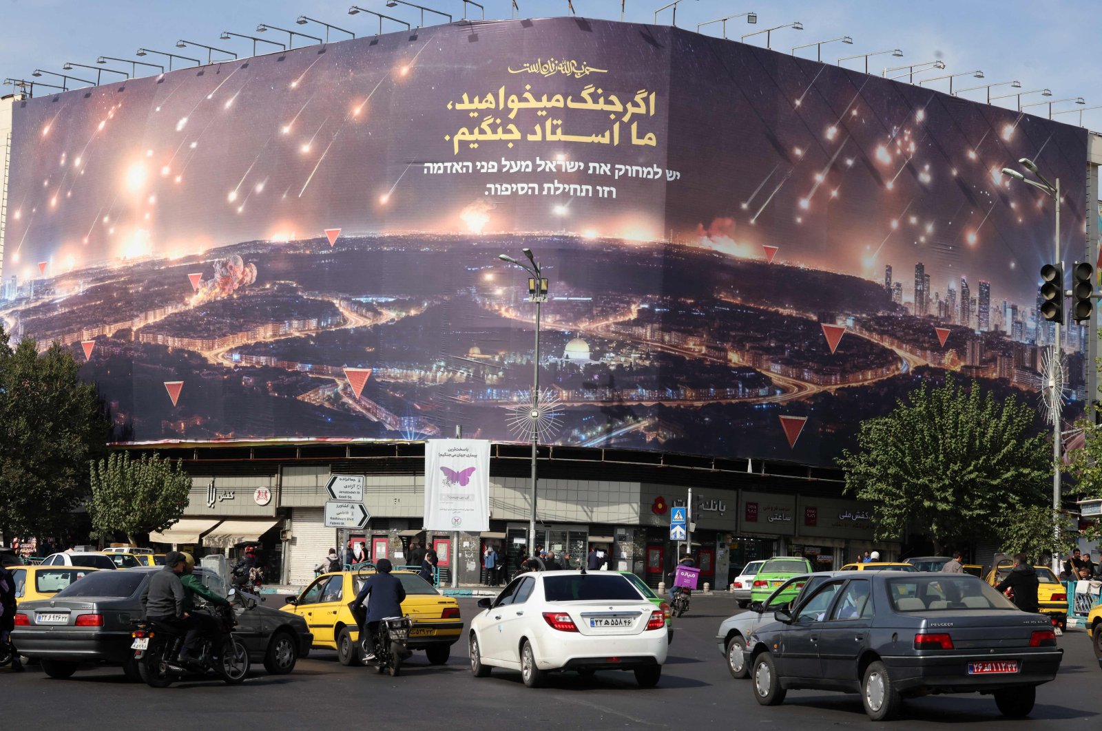 Commuters drive past an anti-Israel billboard covering the facade of a building in Tehran, Iran, Oct. 26, 2024. (AFP Photo)