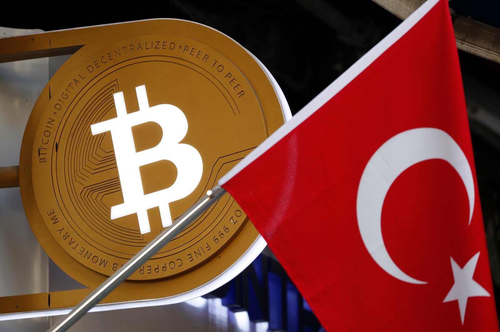 A Bitcoin logo is seen next to the Turkish flag at a cryptocurrency exchange shop, Istanbul, Türkiye, April 27, 2021. (Reuters Photo)