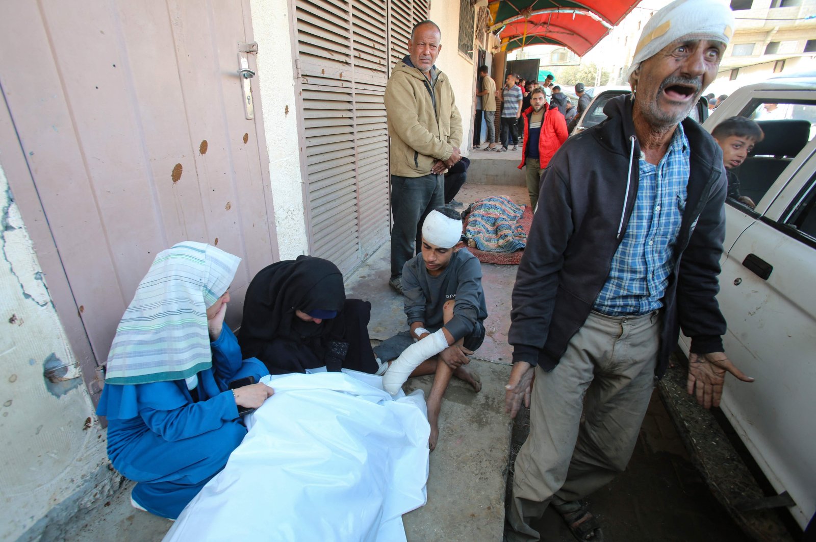 An injured Palestinian man reacts as others surround the body of a victim killed by an Israeli strike on the Nuseirat refugee camp, in front of the al-Aqsa Martyrs hospital, Deir el-Balah, Gaza Strip, Palestine, Nov. 1, 2024. (AFP Photo)